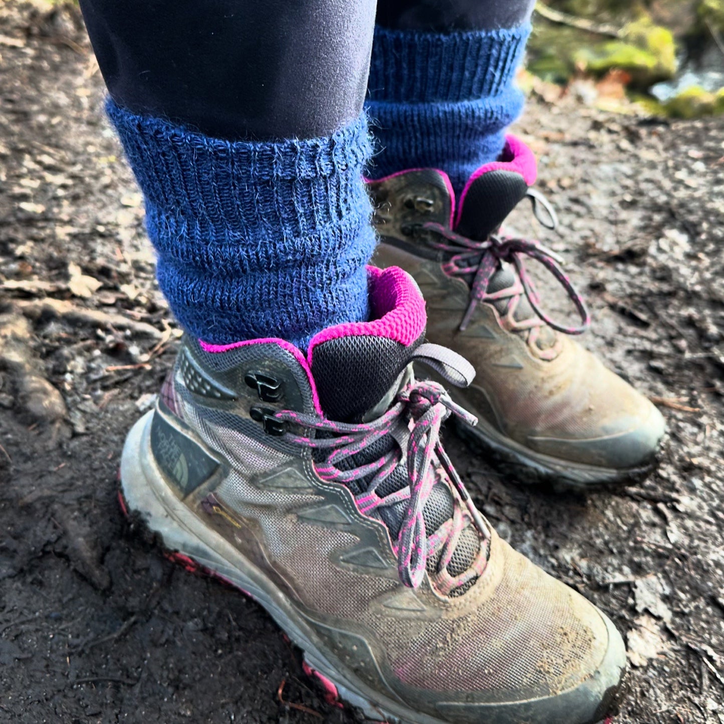 Navy ankle-length Capricorn Mohair Socks worn with hiking boots on a muddy trail – perfect for warmth, comfort and outdoor adventures.