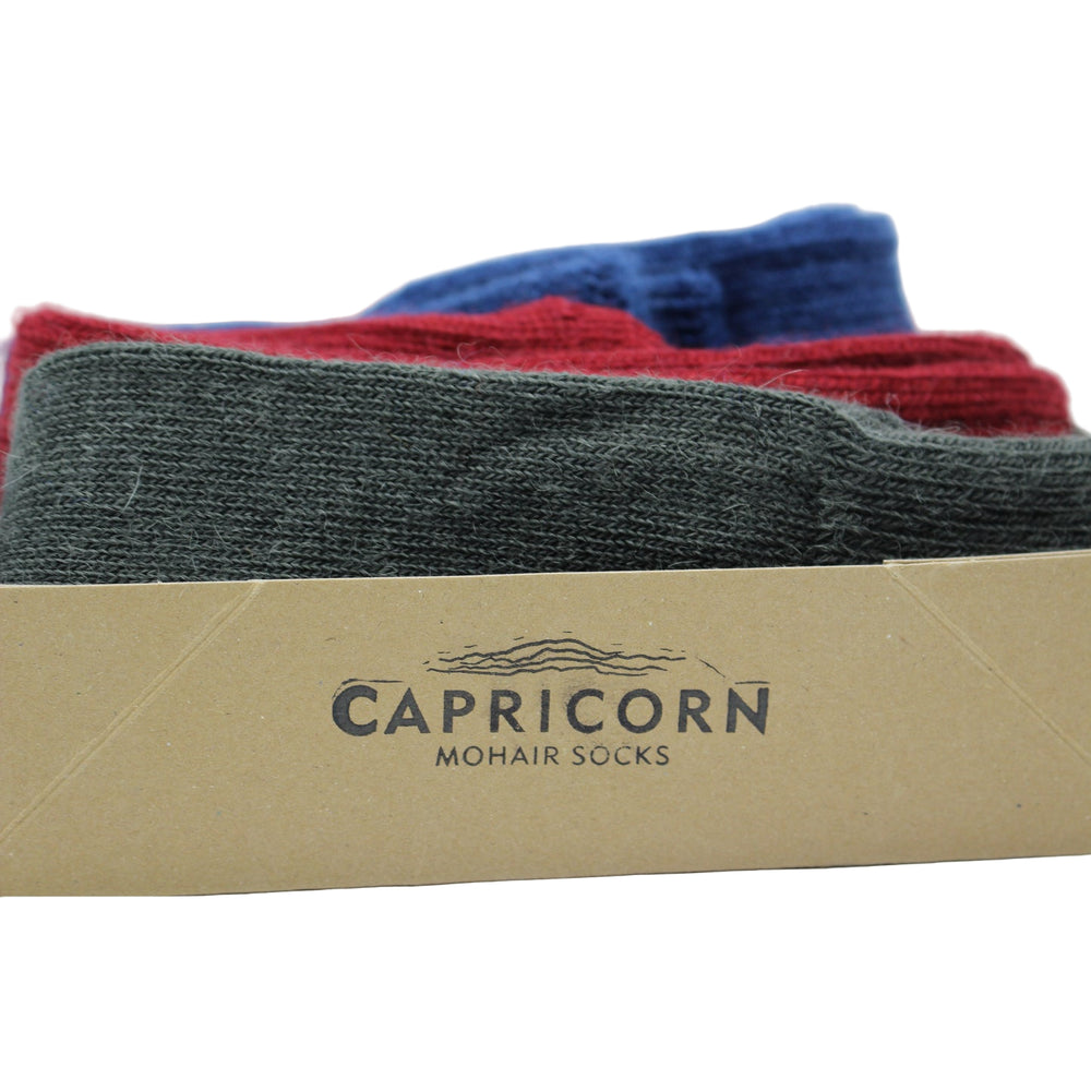
                      
                        Box of Capricorn mohair socks with three pairs of socks inside on a light blue background - Gift for the Gardener
                      
                    