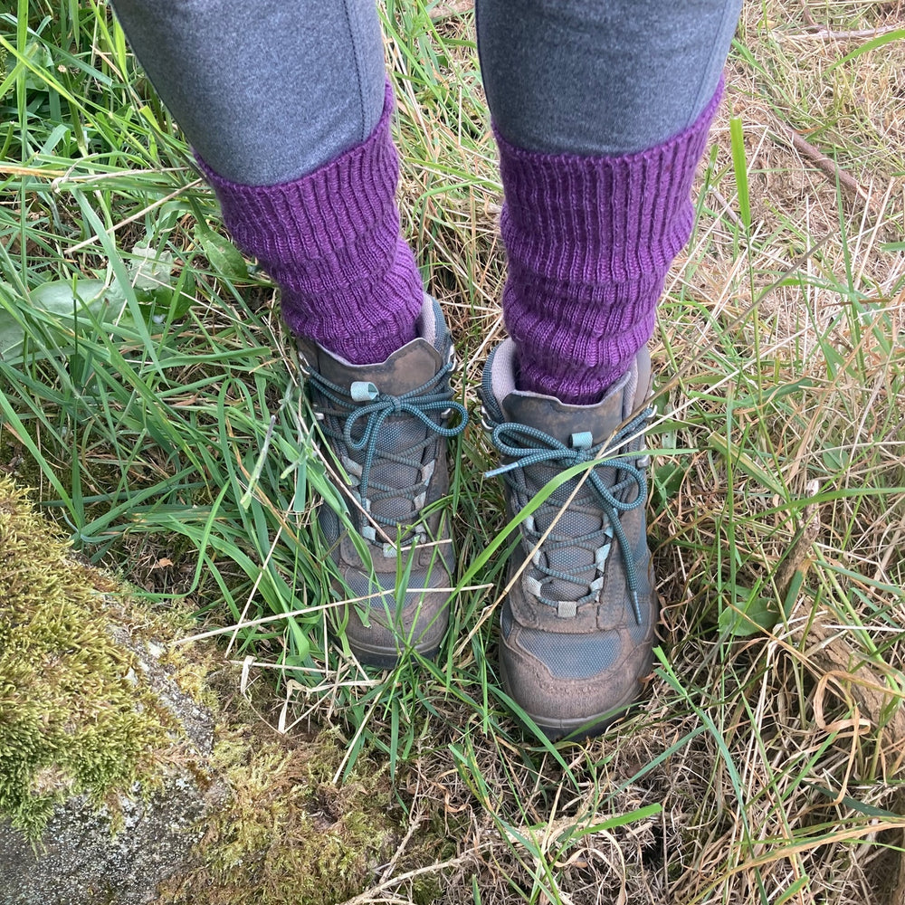 
                      
                        Damson purple Yorkshire-style Capricorn Mohair Socks worn with walking boots in long grass – durable and warm for countryside hiking
                      
                    